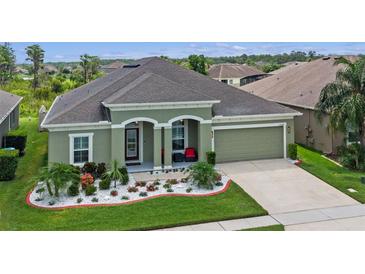 Inviting single-story home with a well-manicured lawn and colorful flower beds enhancing its curb appeal at 12289 Prairie Plantation Way, Orlando, FL 32824