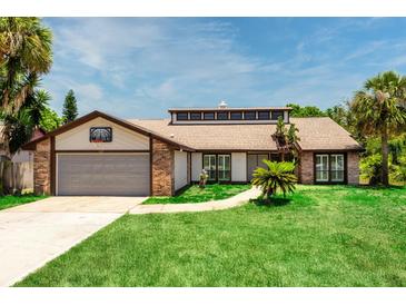 Charming single-story home featuring a brick and vinyl exterior, lush lawn, and an attached garage with a basketball hoop at 140 Margate Mews, Longwood, FL 32779