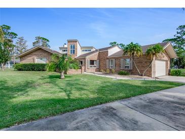 Charming brick home with well-manicured lawn and beautiful landscaping details at 169 Mallard Ln, Daytona Beach, FL 32119