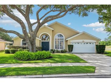 Charming single-story home with a well-manicured lawn, mature trees, and an attached two-car garage at 2598 Ekana Dr, Oviedo, FL 32765