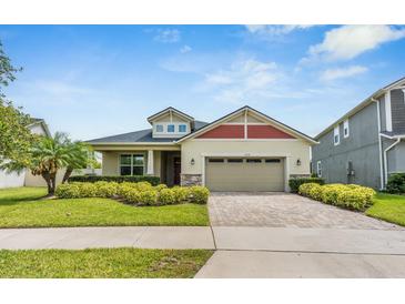 Charming single-Gathering home featuring a manicured lawn, brick driveway, and a two-car garage at 2938 Bushmead Ct, Ocoee, FL 34761