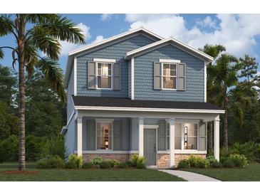 Charming two-story home featuring a covered front porch, blue siding, and lush landscaping at 305 Platform Ln, Debary, FL 32713