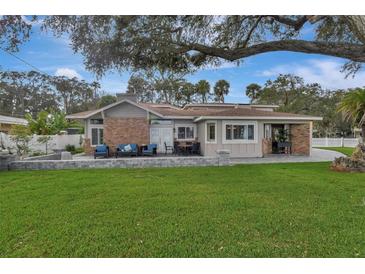 Charming single-story home with a brick facade, inviting patio, and lush green lawn at 434 S Beach St, Ormond Beach, FL 32174