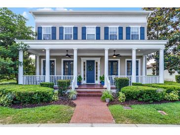 Charming two-story home featuring a welcoming front porch with columns and manicured landscaping at 4474 Enders St, Orlando, FL 32814