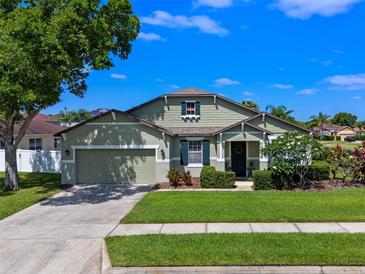 Charming home with an attached garage, a welcoming front porch, and manicured landscaping at 570 Cascading Creek Ln, Winter Garden, FL 34787