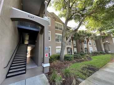 Inviting multi-story condo building with well-maintained landscaping, mature trees, and convenient stairwell access at 7147 Yacht Basin # 132, Orlando, FL 32835