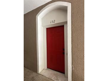 Apartment 132 features a red front door with an arched entrance at 7147 Yacht Basin # 132, Orlando, FL 32835
