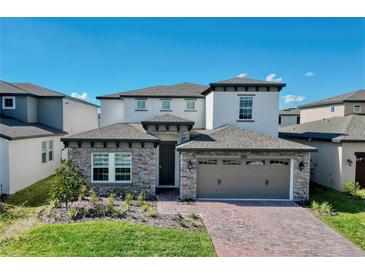 Beautiful two-story home with stone accents and a brick driveway at 1210 Lone Palm Way, St Cloud, FL 34771