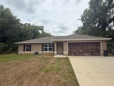 Charming single-story home featuring a well-maintained lawn and a two-car garage at 14598 Se 28Th Ct, Summerfield, FL 34491