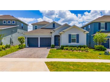 Charming single-Gathering home features a two-car garage, blue accents, and well-maintained landscaping at 2591 Seagirt Way, Clermont, FL 34711