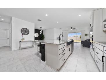 Modern kitchen features granite countertops, stainless steel appliances, and an open design for entertaining at 2591 Seagirt Way, Clermont, FL 34711