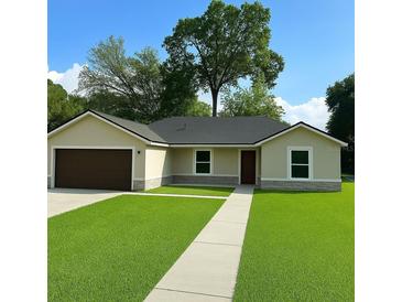 Charming one-story home featuring a well-manicured lawn and inviting entrance at 3082 Se 140Th Ln, Summerfield, FL 34491