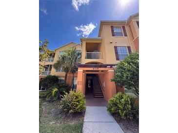 Inviting multi-story condo with well-maintained landscaping and a welcoming entrance under a bright blue sky at 6335 Contessa Dr # 310, Orlando, FL 32829