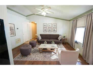 Bright living room with neutral tones, a ceiling fan, hardwood floors, and decor at 10255 Cody Ln, Orlando, FL 32825