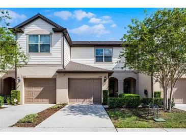 Inviting townhome with a two-car garage and beautifully landscaped front yard at 1109 Pavia Dr, Apopka, FL 32703