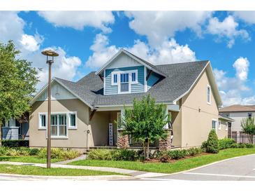 Charming two-story home featuring a manicured lawn, stone accents, and a welcoming front porch in a suburban setting at 13347 Gabor Ave, Orlando, FL 32827