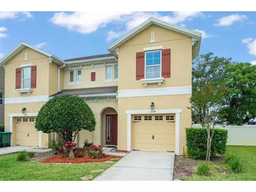 Two-story tan home featuring a front yard with a tree and a single-car garage at 1774 Peterson Pl, Sanford, FL 32773