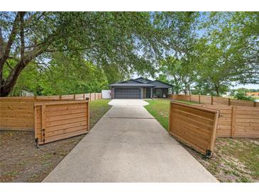 Charming home featuring a long driveway and gated wooden fence offering privacy and curb appeal at 2415 S Oak Ave, Sanford, FL 32771