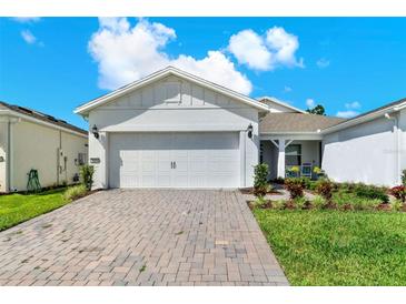 Charming home with brick-paved driveway, manicured lawn, and a white two-car garage at 2458 Cliff Way, St Cloud, FL 34771