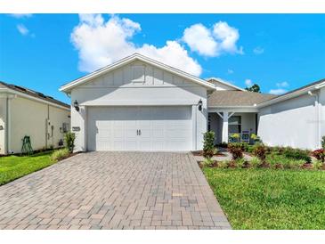 Charming home featuring a two-car garage, well-manicured lawn, and a beautifully paved driveway on a sunny day at 2458 Cliff Way, St Cloud, FL 34771