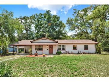 Charming single-story home with a well-manicured lawn and mature trees offering shade and curb appeal at 474 Overstreet Ave, Longwood, FL 32750