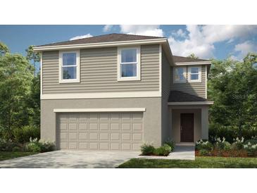 Charming two-story home with a two-car garage and neutral color palette, surrounded by lush landscaping at 5153 Forget Me Not Ave, Lake Hamilton, FL 33851