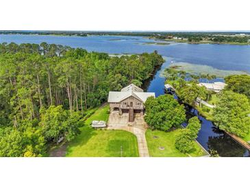 Stunning aerial view of waterfront home with lush trees and expansive waterway views at 6375 Topsy Trl, St Cloud, FL 34771