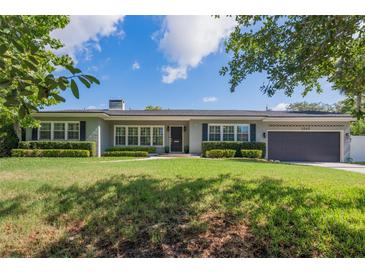 Inviting single-story home with a well-manicured lawn and charming curb appeal and a two car garage at 1245 Munster St, Orlando, FL 32803