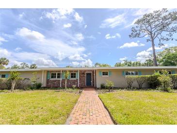 Charming single-story home featuring a brick facade, well-manicured lawn, and inviting walkway at 2001 Lily Ct, Sanford, FL 32771