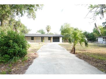 Charming single-story home with a long driveway and lush landscaping at 240 W Palmetto Ave, Deland, FL 32720