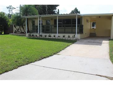 Charming single-story home featuring a covered porch, a well-manicured lawn, and a private driveway at 2808 Drake Dr, Orlando, FL 32810