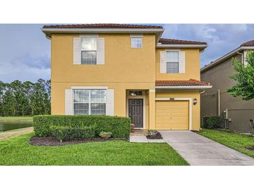 Inviting two-story home featuring a well-maintained lawn and an attached one car garage at 2999 Buccaneer Palm Rd, Kissimmee, FL 34747