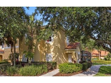 Inviting two-story exterior with lush landscaping, mature trees, and walkway to the front door at 3193 Yellow Lantana Ln, Kissimmee, FL 34747