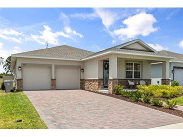 Charming single-story home featuring a two-car garage and inviting front porch at 3981 Great Smokey Way, Apopka, FL 32712