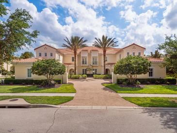 Beautiful building facade with palm trees, red tile roof, red brick drive, and inviting curb appeal at 10371 Kensington Shore Dr # H-201, Orlando, FL 32827