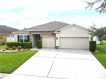Charming single-Gathering home featuring a well-manicured lawn and a spacious three-car garage at 318 Briarbrook Ln, Haines City, FL 33844