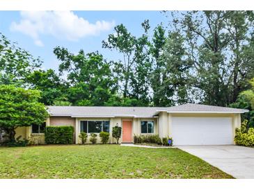 Charming single-story home featuring a well-maintained lawn, mature trees, and a welcoming front entrance at 327 Ketch Ct, Orlando, FL 32835