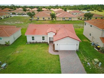 Well-maintained single-Gathering home with lush green lawn and attached garage, surrounded by similar properties at 459 Cinnamon Dr, Kissimmee, FL 34759