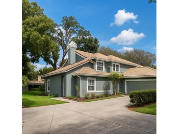 Charming two-story home features a lovely front yard, neutral color scheme, and a tile roof at 4652 Oak Arbor Cir, Orlando, FL 32808