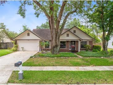 Charming single-story brick home featuring a well-manicured front yard and attached two car garage at 7249 Abbey Ln, Winter Park, FL 32792