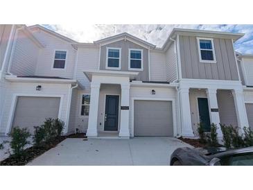 Inviting townhome featuring a modern facade, a private garage, and a well-maintained front yard at 7612 Danube Rd, Kissimmee, FL 34746