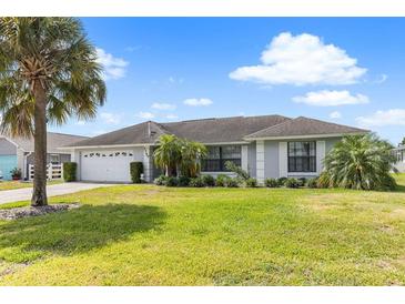 Charming single-story home featuring a lush lawn, well-maintained landscaping, and a spacious two-car garage at 7760 Indian Ridge N Trl, Kissimmee, FL 34747