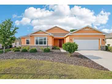 Charming single-story home featuring a well-maintained lawn, attractive landscaping, and an attached two-car garage at 8932 Sw 101St Cir, Ocala, FL 34481