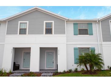 Charming townhome featuring light gray siding, a light-blue front door and matching shutters at 8944 Sydney Ave, Kissimmee, FL 34747