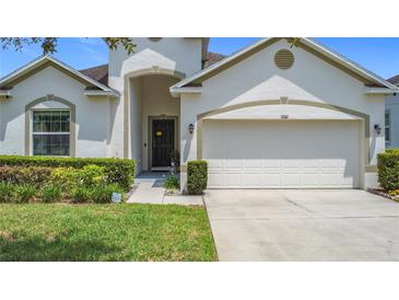 Charming single-Gathering home featuring a two-car garage, well-manicured landscaping and a walkway to the front door at 1061 Suffragatte Cir, Haines City, FL 33844