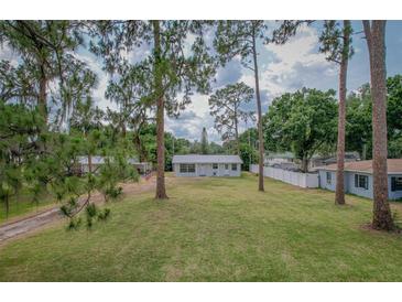 Charming single-story home with a spacious green lawn and mature trees creating a serene setting at 1505 W Lake Cannon Nw Dr, Winter Haven, FL 33881