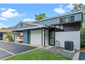 Charming blue townhome featuring a one-car garage, a covered carport and a private front patio at 170 Lago Vista Blvd, Casselberry, FL 32707