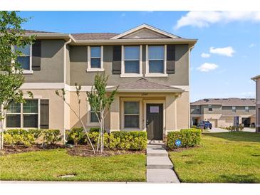 Charming two-story townhome featuring a well-maintained lawn and inviting entrance at 1797 Red Canyon Dr, Kissimmee, FL 34744