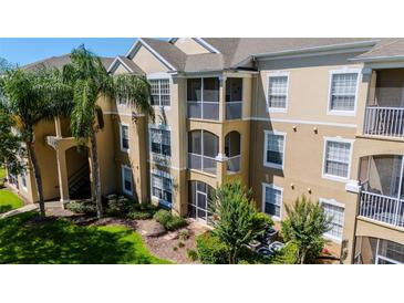 Elegant condominium building featuring balconies, lush landscaping, and a welcoming entrance at 2304 Silver Palm Dr # 304, Kissimmee, FL 34747