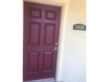 A classic burgundy-colored front door with an address plate on the side, creating an inviting entrance to the home at 2882 Club Cortile Cir # B, Kissimmee, FL 34746
